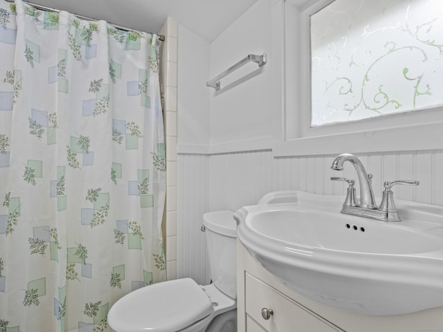 full bathroom with wainscoting, toilet, a shower with curtain, and vanity