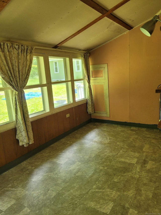 unfurnished room with vaulted ceiling and tile patterned floors