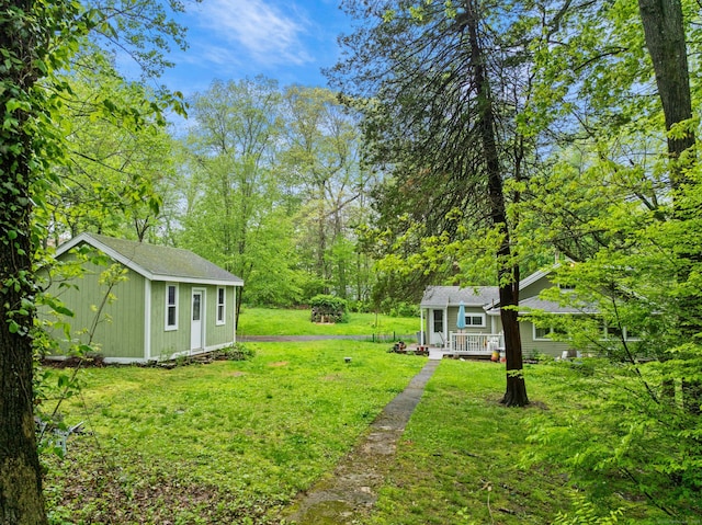 view of grassy yard with an outbuilding and a deck