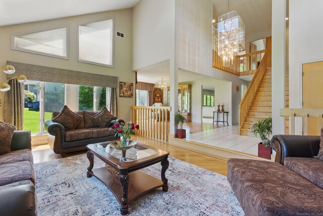 17 Pasture Ln, Glastonbury, CT 06073 - living room with a chandelier, a high ceiling, plenty of natural light, wood finished floors, and stairway