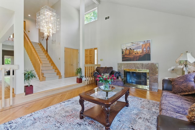 17 Pasture Ln, Glastonbury, CT 06073 - living room with high vaulted ceiling, wood finished floors, a high end fireplace, stairs, and a chandelier