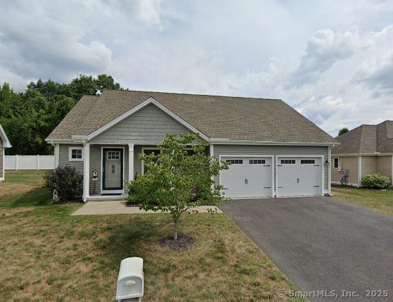 view of front of property featuring a front yard, a garage, fence, and driveway