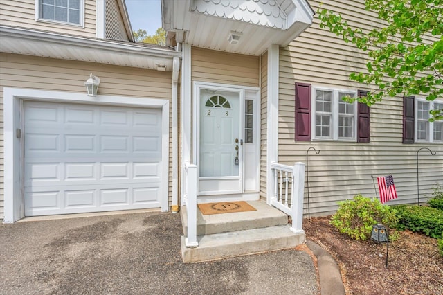 doorway to property featuring asphalt driveway