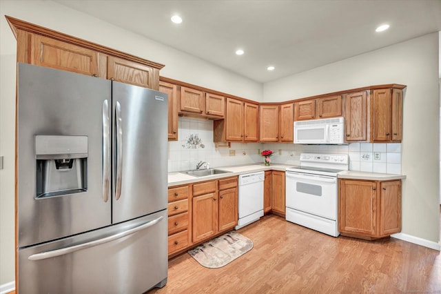 kitchen with white appliances, a sink, light countertops, backsplash, and recessed lighting