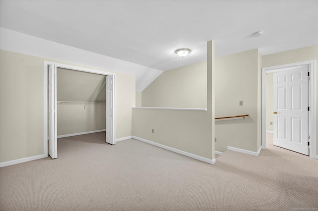 additional living space with carpet floors, vaulted ceiling, and baseboards