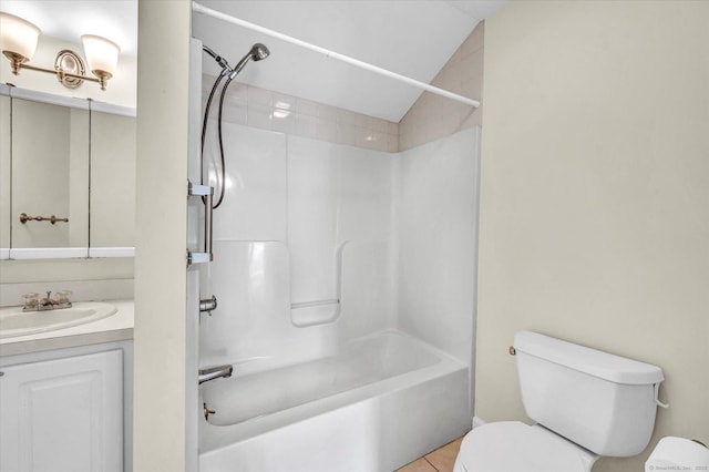 full bath with toilet, vanity, tile patterned floors, vaulted ceiling, and shower / washtub combination
