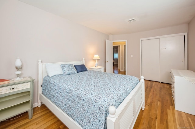 bedroom with a closet, light wood-type flooring, and visible vents