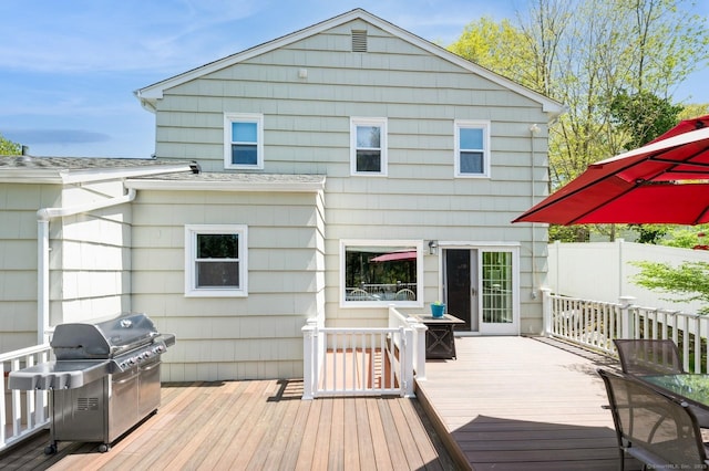 wooden terrace featuring area for grilling and fence