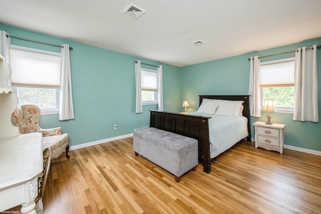 bedroom with visible vents, multiple windows, and light wood-style floors