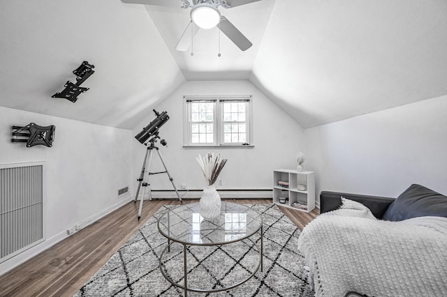 interior space with ceiling fan, wood finished floors, lofted ceiling, a baseboard radiator, and visible vents