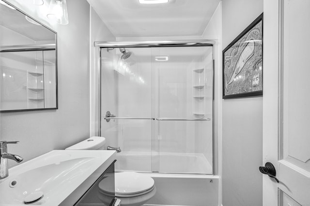 bathroom with toilet, shower / bath combination with glass door, and vanity