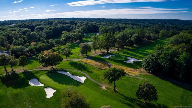 drone / aerial view featuring golf course view and a wooded view