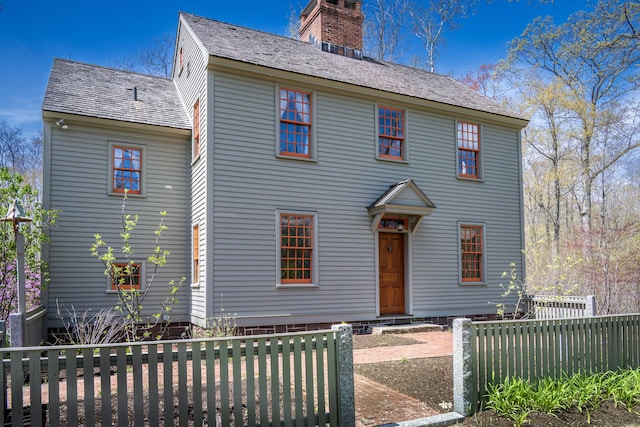 colonial house with a chimney and fence private yard