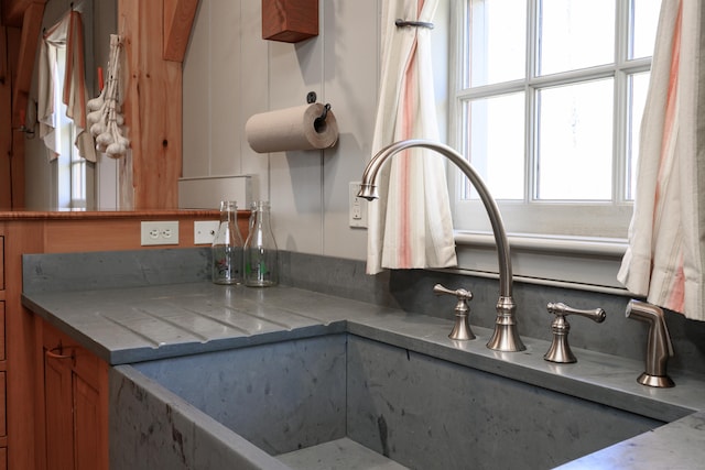 kitchen with a sink, brown cabinetry, and plenty of natural light