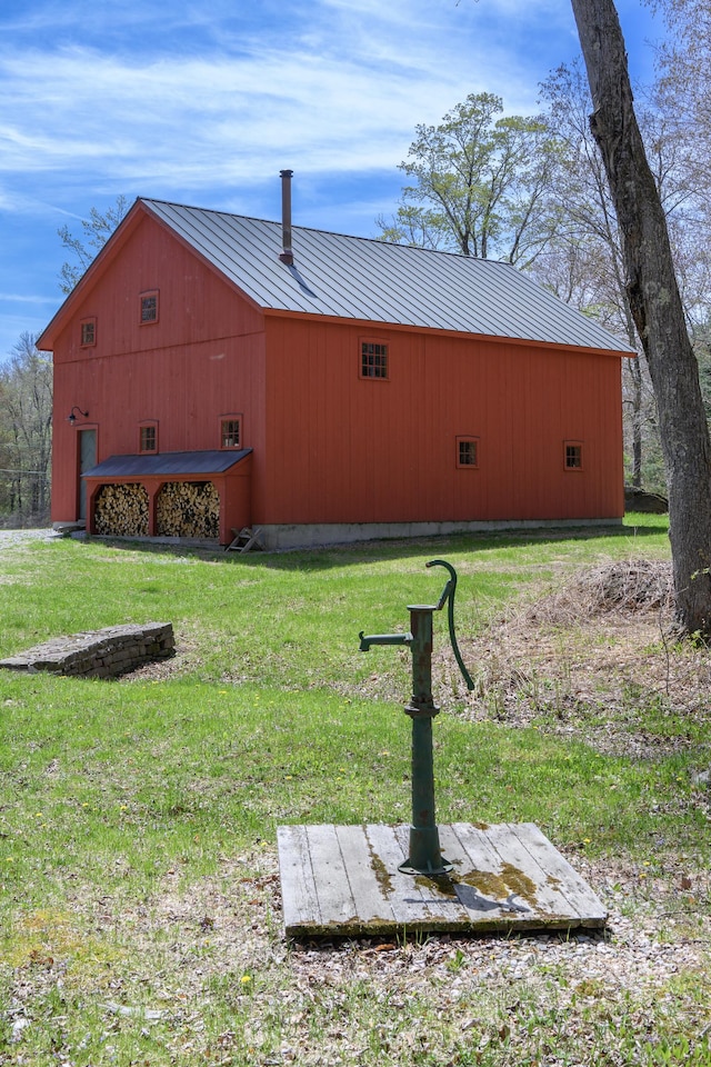 view of property exterior featuring a yard, metal roof, a standing seam roof, and a pole building
