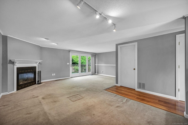 37 Valley Run Dr Unit 37, Cromwell, CT 06416 - unfurnished living room with carpet flooring, track lighting, baseboards, a textured ceiling, and a fireplace with flush hearth