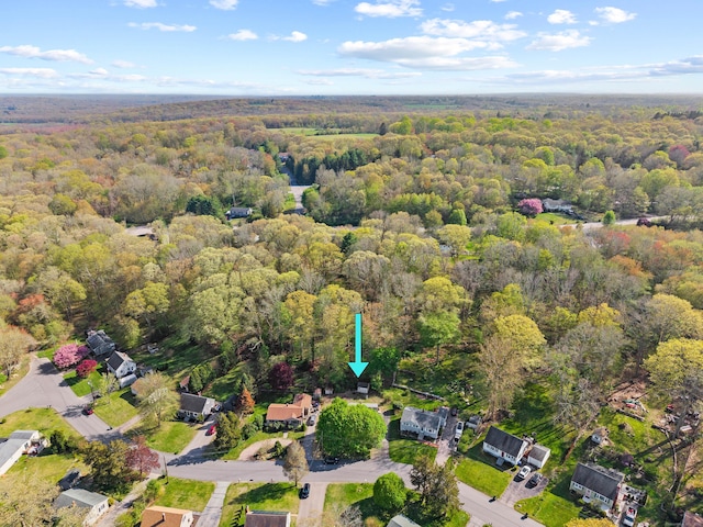 drone / aerial view featuring a wooded view