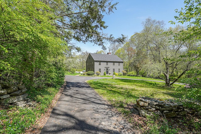 exterior space featuring a chimney and a front yard