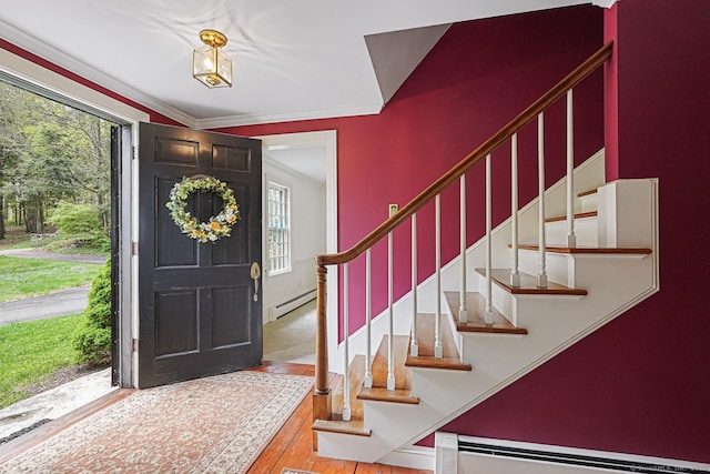 foyer entrance with stairs, a baseboard radiator, baseboard heating, and hardwood / wood-style flooring