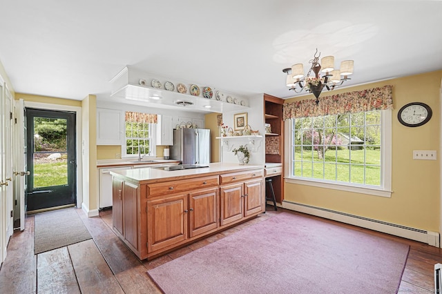 kitchen with an inviting chandelier, freestanding refrigerator, light countertops, a baseboard radiator, and white dishwasher