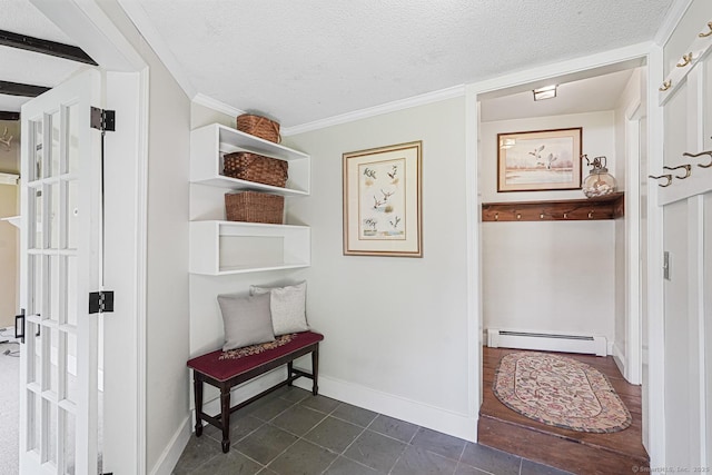 hall with a baseboard heating unit, a textured ceiling, crown molding, dark tile patterned flooring, and baseboards