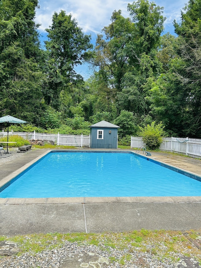 view of pool with an outbuilding, a patio, a fenced in pool, and fence