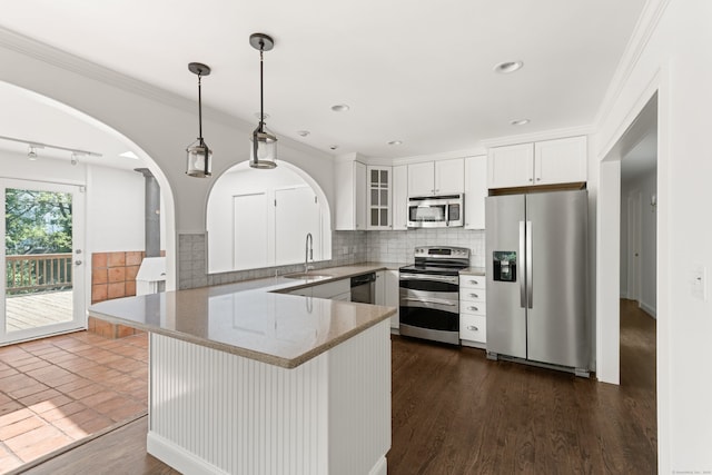 16 Wakerobin Rd, Norwalk, CT 06851 - kitchen with stainless steel appliances, a sink, arched walkways, decorative backsplash, and pendant lighting