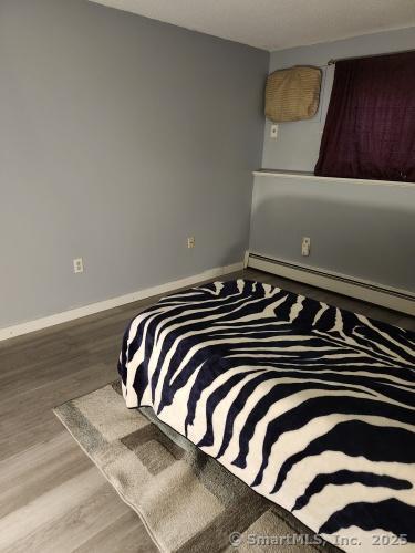 58 Evergreene Unit 58, Wallingford, CT 06492 - bedroom with baseboards and wood finished floors