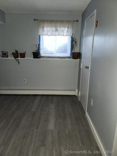 58 Evergreene Unit 58, Wallingford, CT 06492 - unfurnished room featuring baseboard heating, dark wood-style flooring, and baseboards