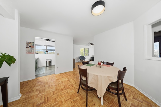 dining space featuring ceiling fan and baseboards