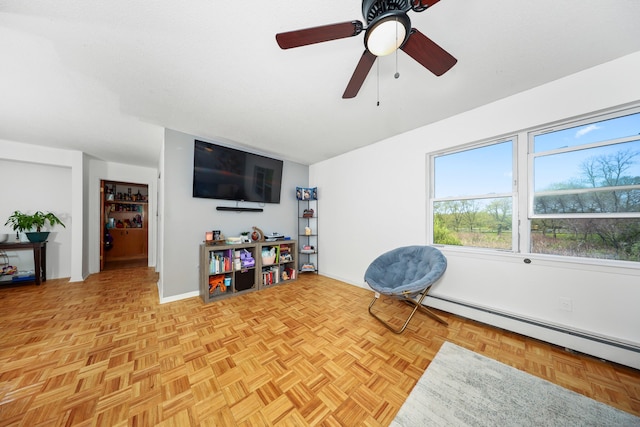 living area featuring baseboard heating and a ceiling fan