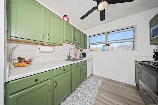 kitchen featuring a sink, green cabinetry, white dishwasher, and electric range