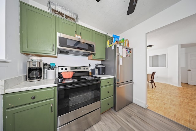 kitchen with light countertops, ceiling fan, green cabinets, and stainless steel appliances