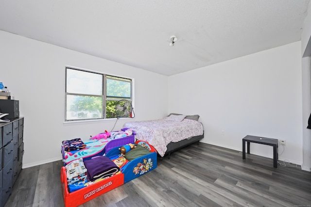 bedroom featuring baseboards and dark wood finished floors