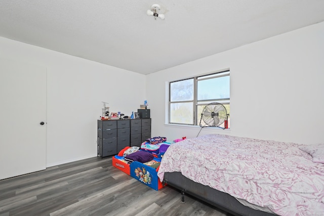 bedroom featuring baseboards and wood finished floors