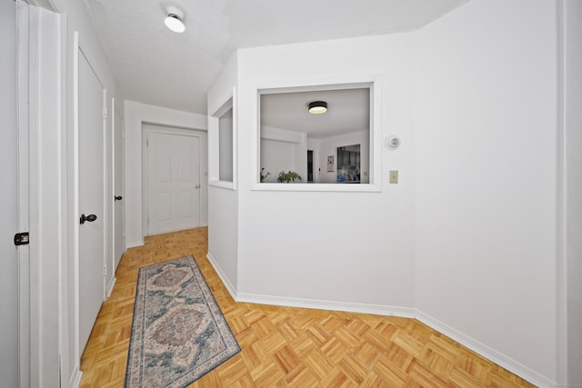 hallway featuring baseboards and a textured ceiling