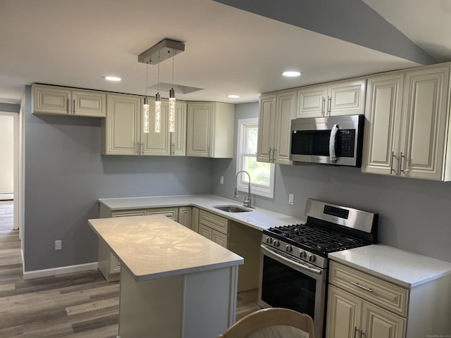 kitchen featuring a center island, light wood-type flooring, a sink, light countertops, and stainless steel appliances