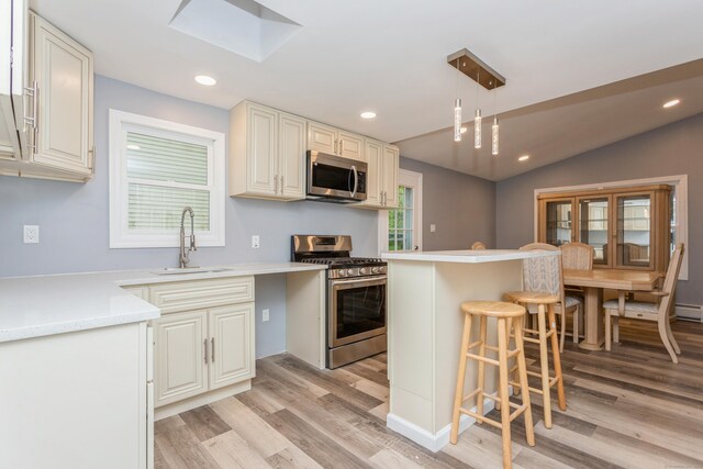 75 Edwards St, Bridgeport, CT 06606 - kitchen featuring stainless steel appliances, a sink, light wood-style floors, a kitchen breakfast bar, and recessed lighting