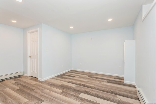 75 Edwards St, Bridgeport, CT 06606 - basement featuring baseboard heating, recessed lighting, light wood-style floors, baseboards, and a baseboard radiator