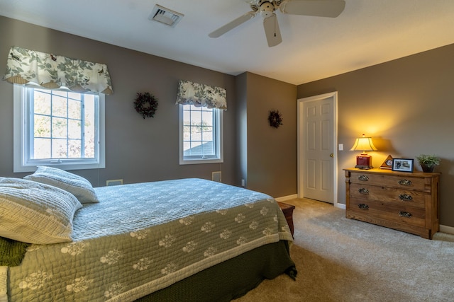 bedroom featuring visible vents, a ceiling fan, baseboards, and carpet floors