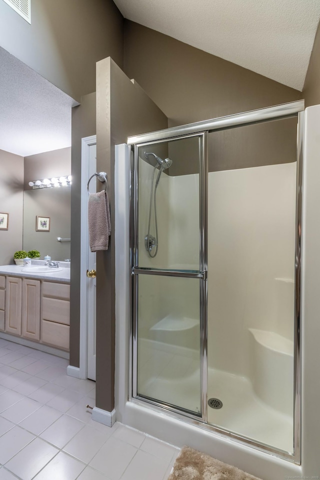 bathroom featuring visible vents, vaulted ceiling, a shower stall, and tile patterned flooring