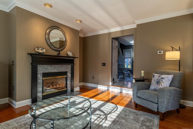 living room with visible vents, crown molding, wood finished floors, baseboards, and a premium fireplace