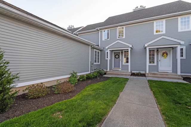 view of front of home with a chimney and a front lawn