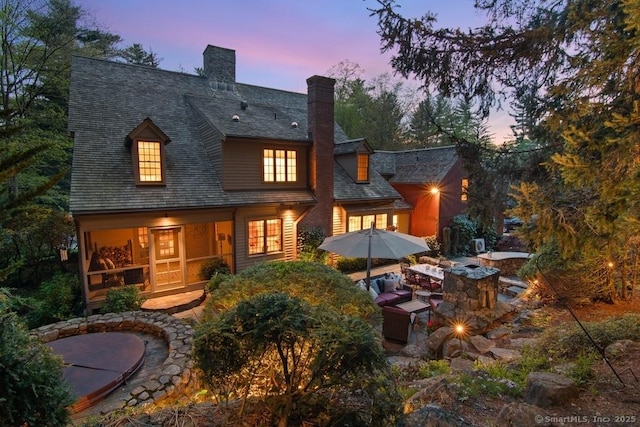 back of house with a chimney, a fire pit, and a patio area