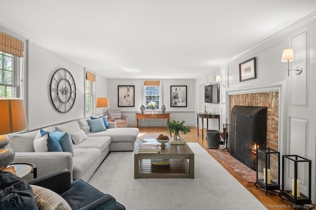 living area featuring wood finished floors and a brick fireplace