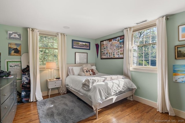 bedroom with light wood-style floors and baseboards