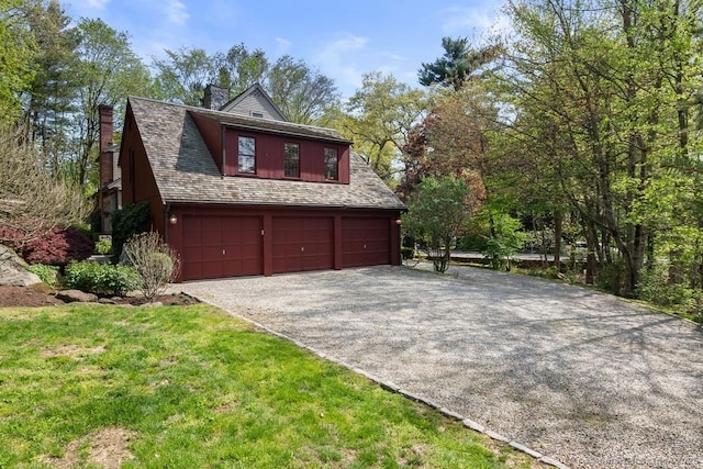 view of home's exterior featuring a chimney, a garage, and driveway