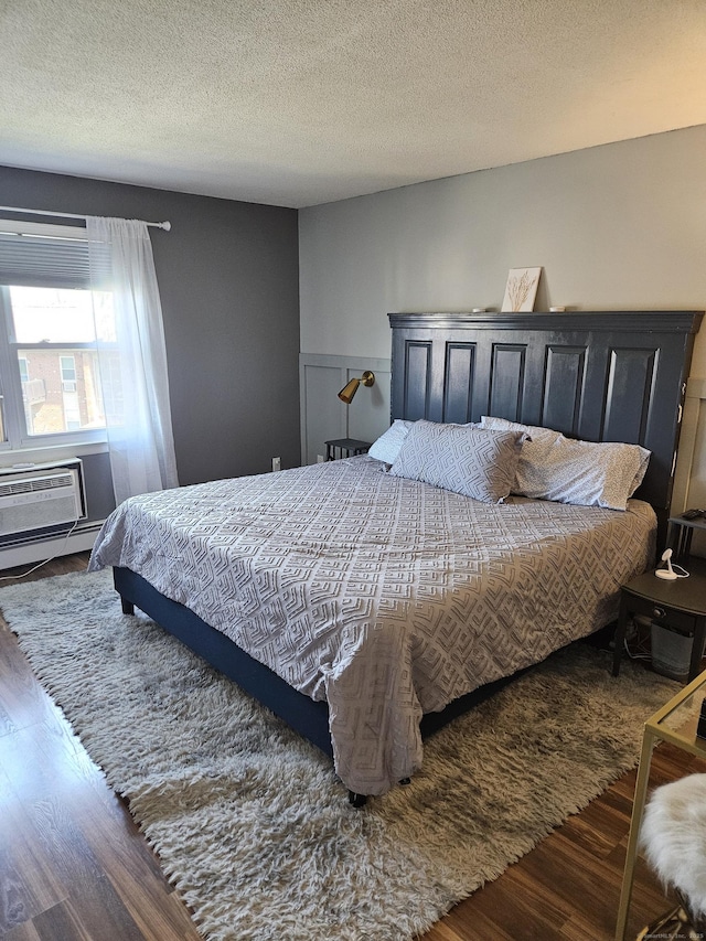 bedroom featuring wood finished floors and a baseboard radiator