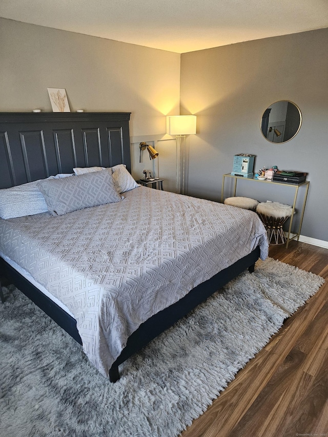 bedroom featuring baseboards and wood finished floors