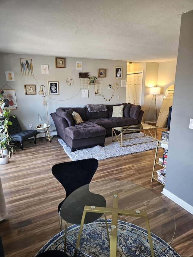 living room with a textured ceiling and wood finished floors